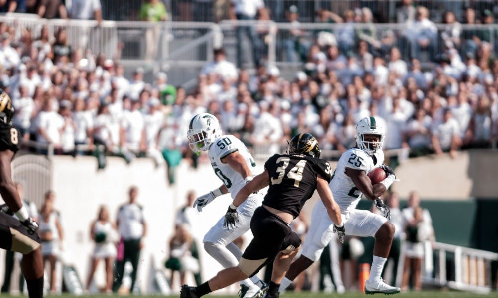 <p>Sophomore wide receiver Darrell Stewart Jr. (25) rushes with the ball as senior linebacker Sean Harrington guards him during the game against Western Michigan University on Sep. 9, 2017 at Spartan Stadium. The Spartans defeated the Broncos 28-14.</p>