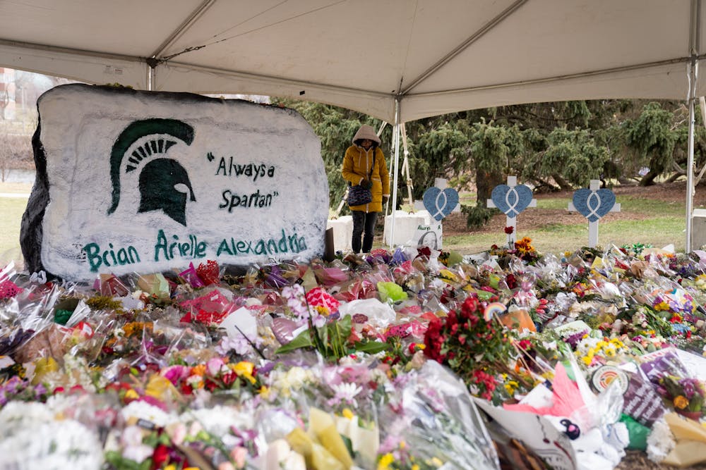 The Rock on Farm Lane surrounded by flowers and messages of support on Feb. 21, 2023. 