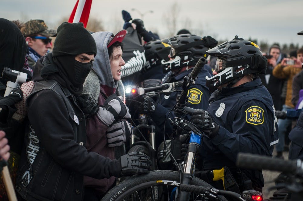 <p>East Lansing Police officers use their bikes to push back the crowd during the protests to stop Richard Spencer from speaking at MSU on March 5, 2018 at MSU Pavilion. (C.J. Weiss | The State News)</p>