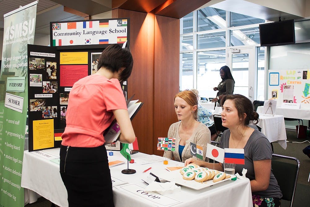 <p>Senior special education major Christine Chern (left) stops by the Community Language School booth to speak with Heather Brown (middle) and Hannah Jenuwine (right) at the Earn Learn & Intern Fair held on the fourth floor of Spartan Stadium on Wednesday, Sept. 8. Griffin Zotter/The State News</p>