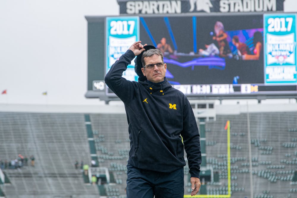 <p>Michigan football head coach Jim Harbaugh walks to the locker room after surveying the field before kickoff at Spartan Stadium on Oct. 30, 2021.</p>