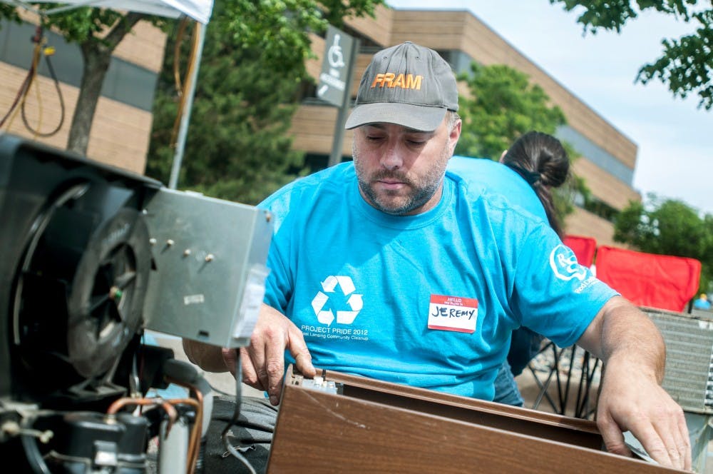 Jeremy Deforest of Mason, Mich. disassembles recycled dehumidifiers during Project Pride, Saturday, June 2, 2012 at the Abbott Center.  The event encourages East Lansing residents to recycle old materials and appliances rather than throwing them away.  Adam Toolin/The State News