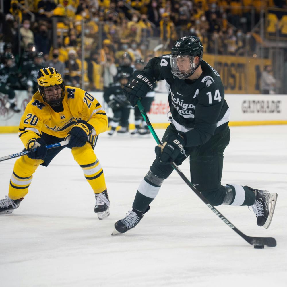 <p>Senior left-wing Adam Goodsir (14) takes a shot against junior right-defense Keaton Pehrson (20). MSU&#x27;s hockey season came to an end after a second loss to the University of Michigan in the Big Ten Men&#x27;s Hockey Tournament at Yost Ice Arena on March 05, 2022.</p>