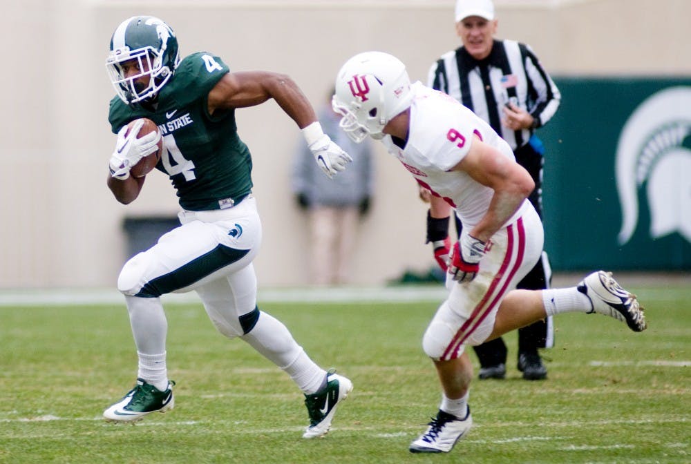 Junior running back Edwin Baker rushes past Indiana cornerback Greg Heban down the field during Saturday's game in Spartan Stadium. The Spartans defeated the Hoosiers, 55-3. Lauren Wood/The State News