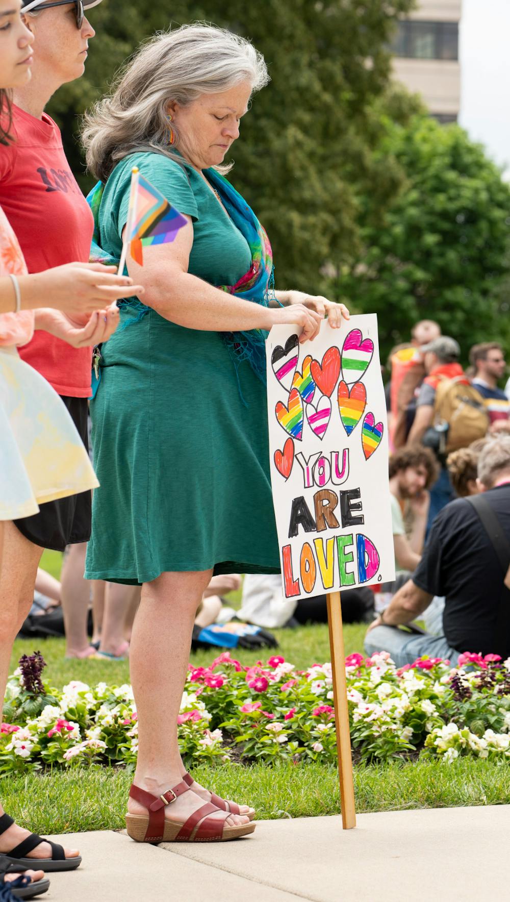 An attendee of the Lansing pride rally holds a sign that says "you are loved" on June 26, 2022.