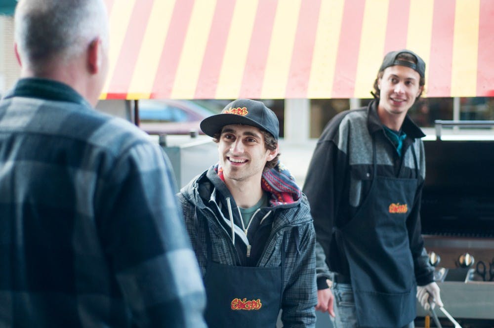 	<p>East Lansing resident Dudley Smith, left, talks with biochemistry and molecular biology junior Mac Hyman, middle, and food industry management senior Nino Rabhi, right May 11, 2013, at the Spicers Grill food cart on Albert Avenue and Division Street. Rabhi said the grill will mainly stay at Albert Avenue and Division Street, but will move to other locations in East Lansing. Weston Brooks/The State News</p>