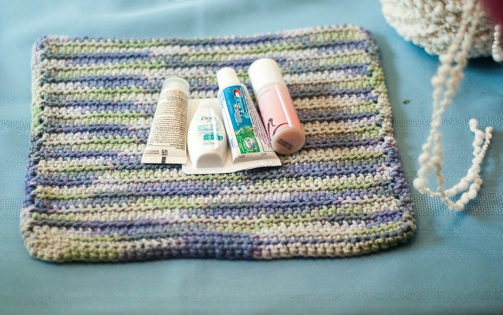 	<p>A hand-knit washcloth sits on the kitchen table with toothpaste, soap and shampoo in preparation to be wrapped on July 29, 2013, at the home of Emily Trumbull in Lansing. Trumbull, along with her friend and Lansing resident Tilly Montaven, wrap the toiletries in order to give them to various shelters in the Lansing area. Danyelle Morrow/The State News</p>