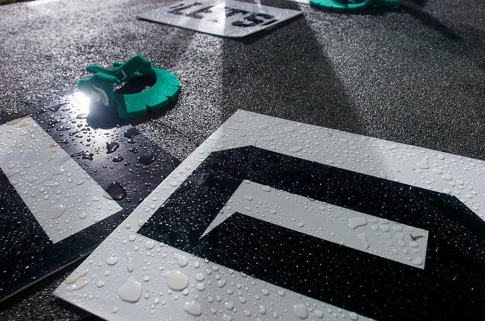 	<p>Signs used by the Spartan cheerleaders are covered in water after the rain delay ends on Aug. 30, 2013, at Spartan Stadium. The Spartans defeated the Broncos, 26-13. Katie Stiefel/The State News</p>