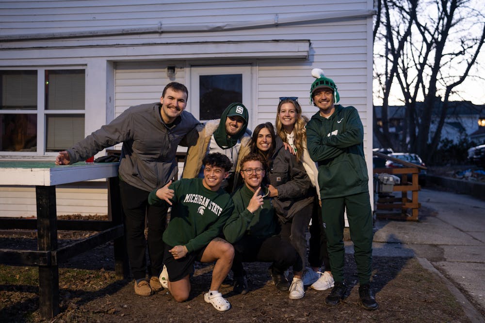 A group of friends poses for a photo after celebrating the Spartans' win against Marquette during March Madness on March 19, 2023. The Spartans defeated the Golden Eagles 69-60. 