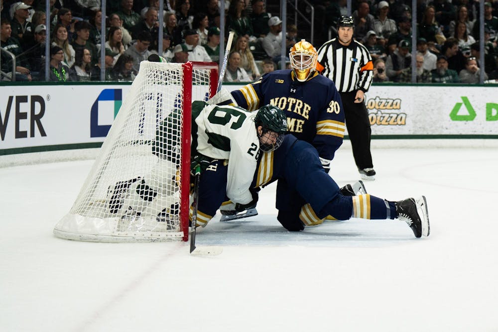 <p>A Notre Dame defender shoves Michigan State senior right wing Tanner Kelly (26) into the Notre Dame goal at Munn Ice Arena on March 15, 2025. The Spartans took a 1-0 victory over the Fighting Irish, advancing to the Big Ten Championship.</p>