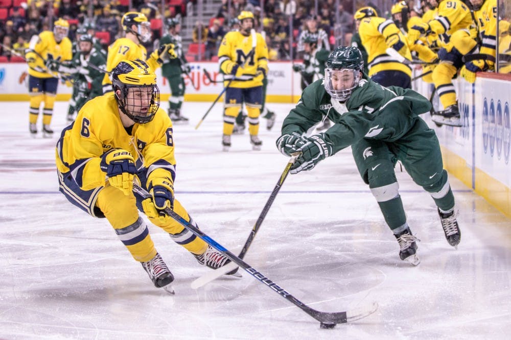Sophomore forward Taro Hirose (17) reaches for the puck during the game against Michigan on Feb. 10, 2018, at Little Caesars Arena. The Spartans fell to the Wolverines, 3-2.