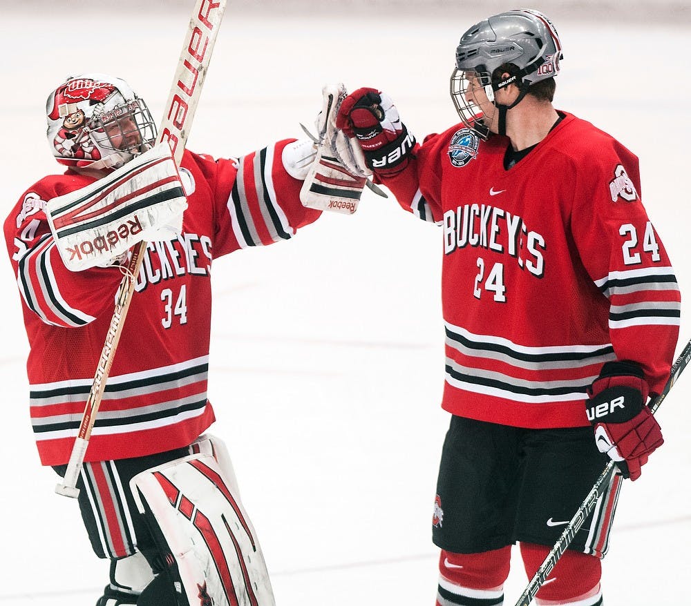 	<p>Buckeye goaltender Brady Hjelle celebrates a shutout victory with defensemen Craig Dalrymple Friday night, Nov. 30, 2012, at Munn Ice Arena. The Ohio State Buckeyes defeated the Spartans, 1-0, with a late goal in the third period. Adam Toolin/The State News</p>