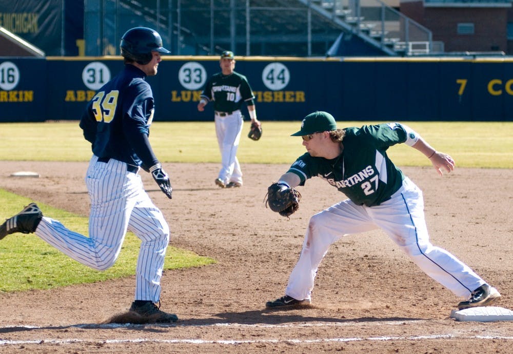 Senior first baseman Jeff Holm gets his foot on the base before Michigan designated hitter Brett Winger can reach it Sunday at Ray Fisher Stadium at Wilpon Baseball Complex in Ann Arbor. The Spartans defeated the Wolverines, 8-2, in the second game of a double header. Matt Radick/The State News