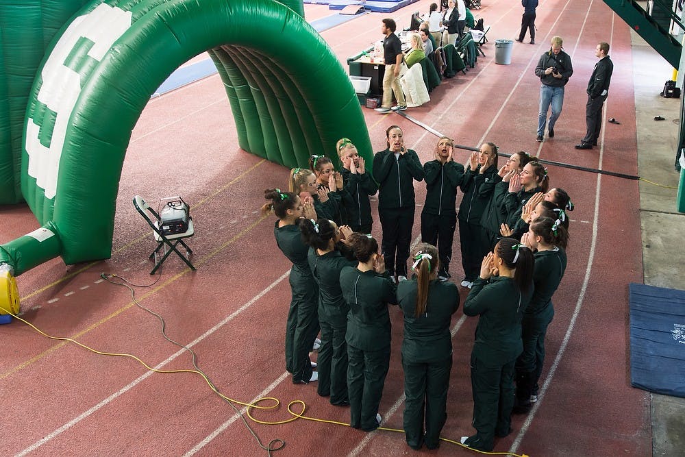 	<p>The gymnastics team sings the fight song before competition against Penn State on Jan. 25, 2014, at Jenison Field House. <span class="caps">MSU</span> lost the meet, 192.750-194.825. Casey Hull/The State News</p>