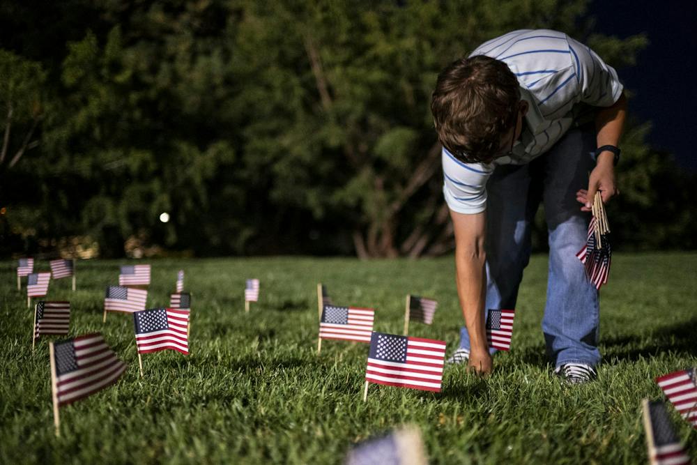 <p>A member of MSU Young Americans for Freedom places an American flag in the ground during preparations for a 9/11 memorial at The Rock on Michigan State University’s campus in East Lansing, Mich., on Thursday, Sept. 10, 2026. The organizations placed 2,977 flags around The Rock, one for each victim killed in the 9/11 terrorist attacks.</p>