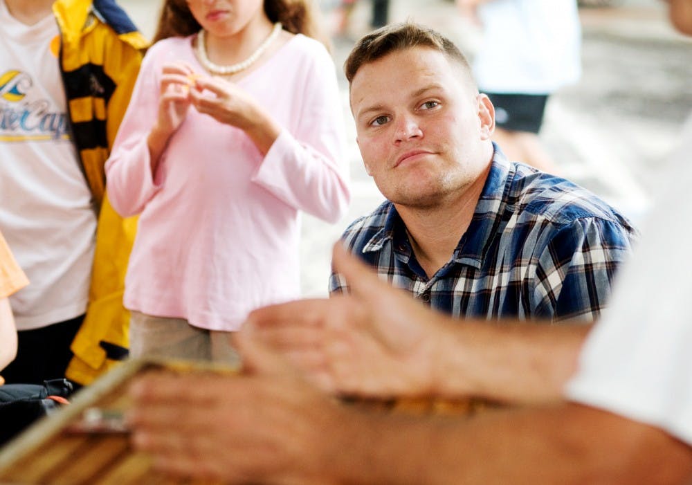 <p>East Lansing resident Bill Heinzelmann listens during a workshop on “beekeeping for bee-ginners” held Sunday at the Great Lakes Folk Festival in East Lansing. The three-day festival featured concerts, dancing and many informational workshops. </p>