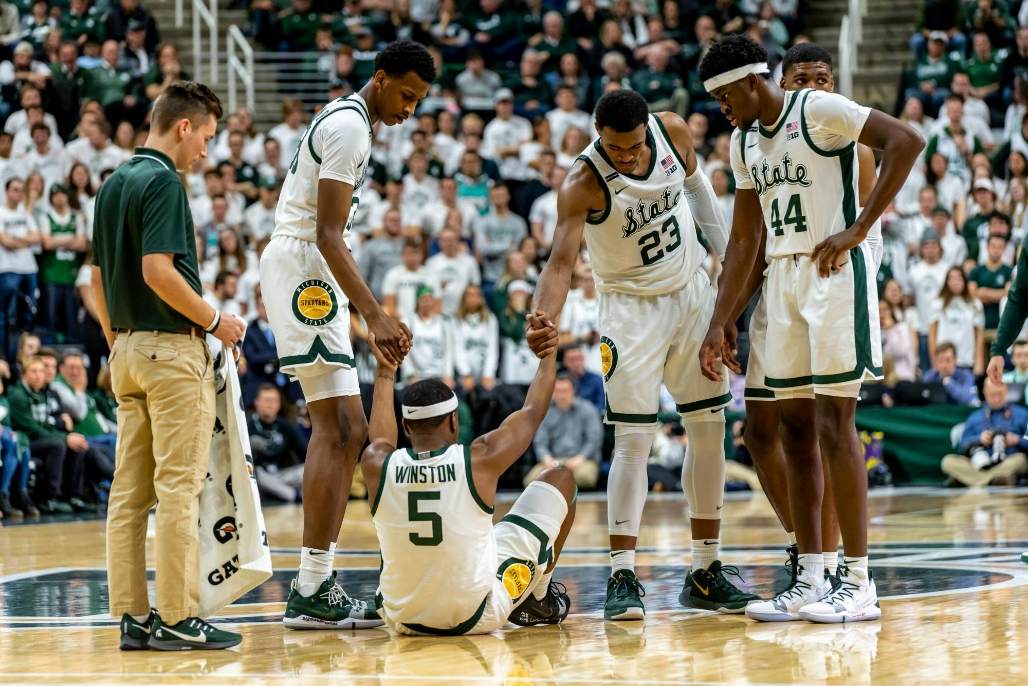 Senior guard Cassius Winston (5) is helped up by his teammates during a game against Northwestern.The Spartans defeated the Wildcats, 79-50, at the Breslin Student Events Center on January 29, 2020. 