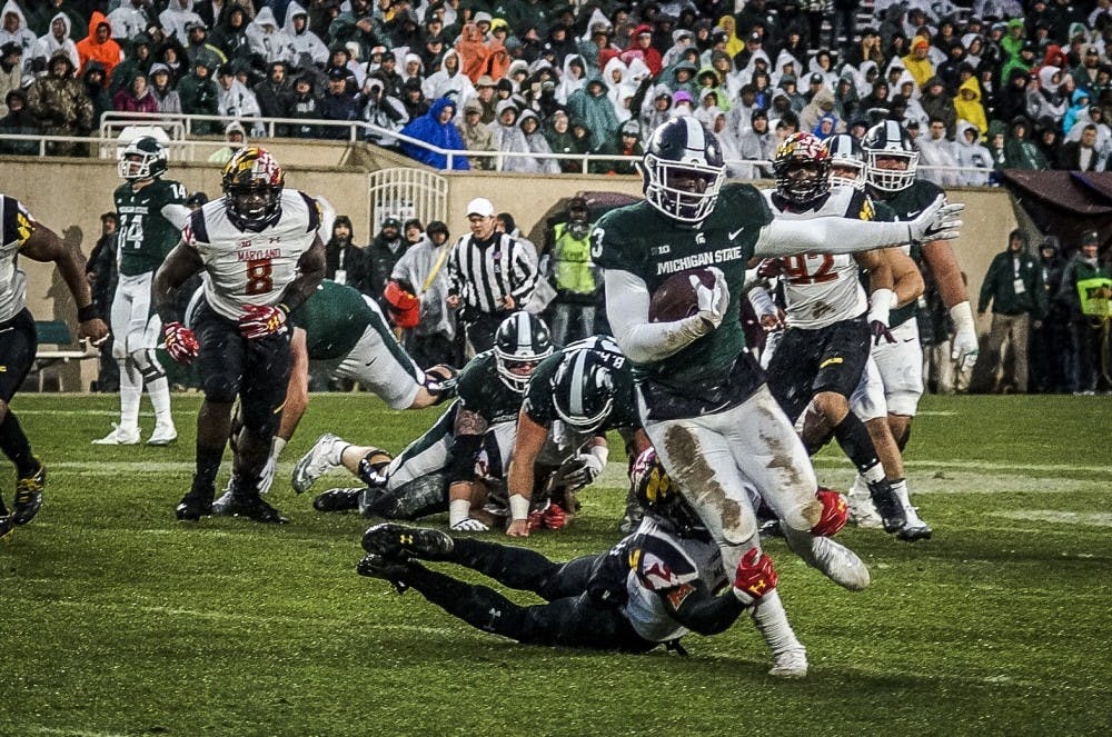 <p>Junior running back LJ Scott (3) is tackled by a Maryland defender during the game against Maryland on Nov. 18, 2017 at Spartan Stadium.</p>