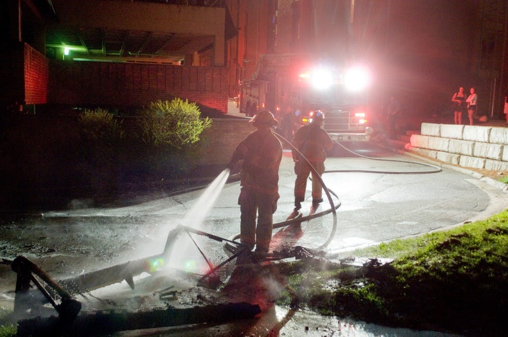 Firefighters put down a burt coach Thursday night at Cedar Village after Michigan State falls to Louisville in NCAA tournament. The State News