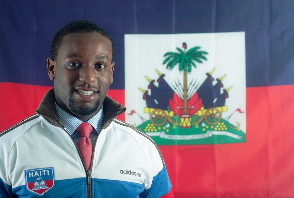 Urban and regional planning senior Emilio Voltaire poses with his Haitian flag on Monday, Sept. 17 in his apartment. Voltaire says he plans to movie to Haiti after graduating from MSU. Griffin Zotter/The State News