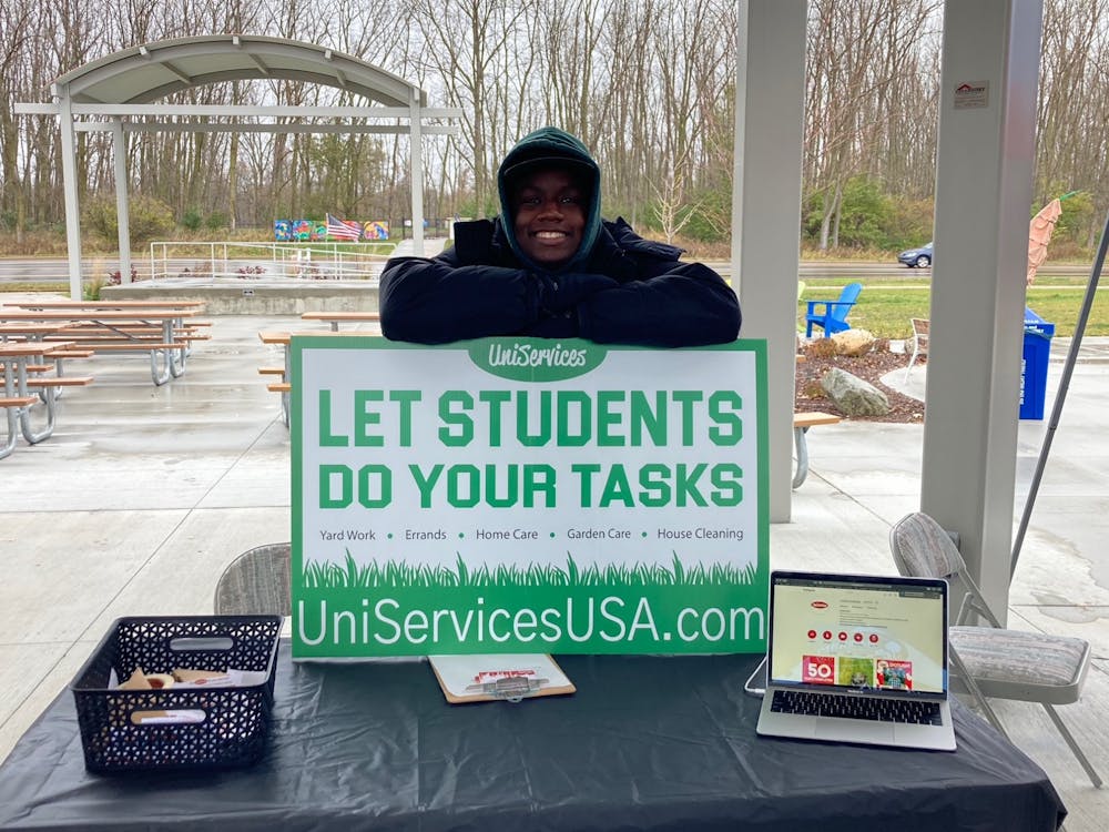<p>Finance junior Quintin Bell at the Meridian Twp Farmer’s Market to advertise UniServices. Photo courtesy of Adam Green.</p>