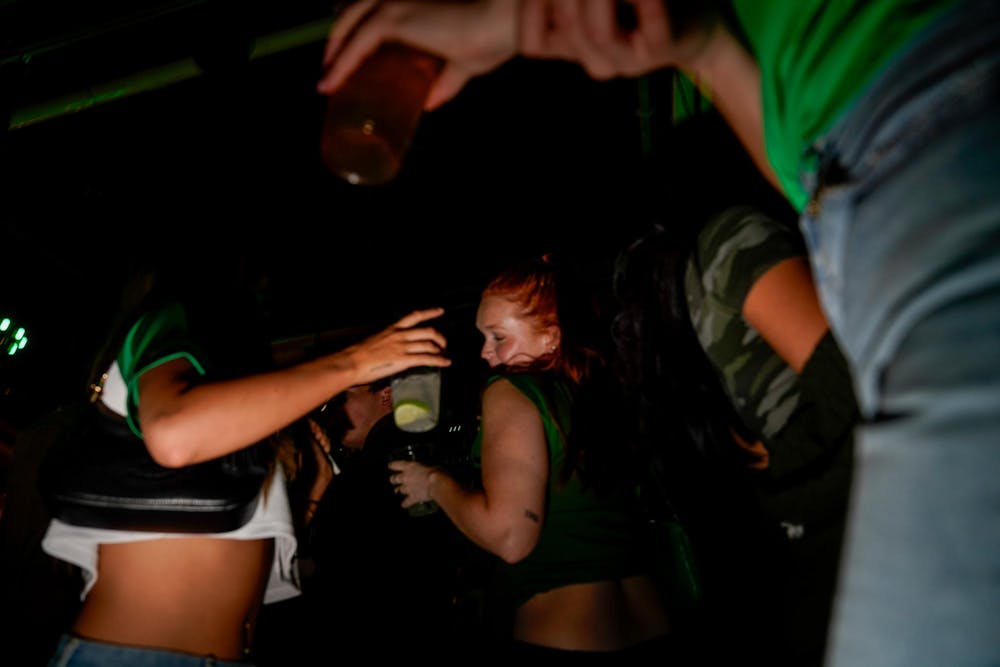 Apparel and textiles senior Alexa Baldini and social work senior Quincy Baxter dance at Mash the night before St. Patrick's Day in East Lansing on March 16, 2024.