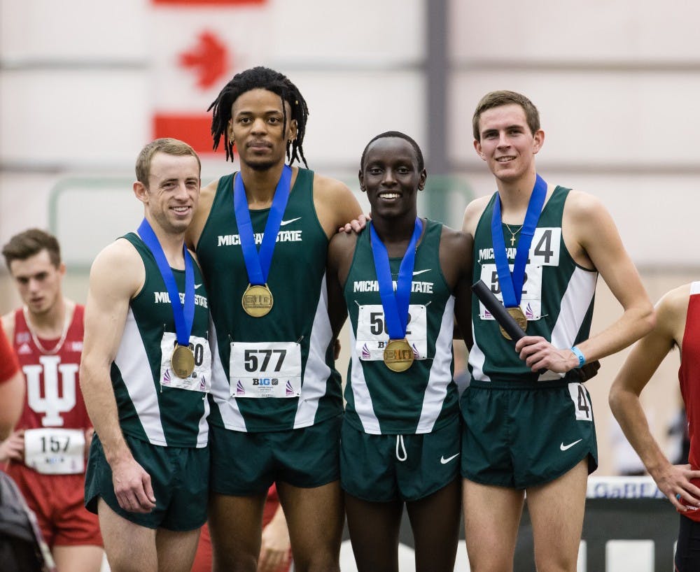 From left to right, distance senior Sherod Hardt, sprint and hurdles senior David Washington, distance sophomore Justine Kiprotich and distance sophomore Dan Sims pose with their medals for a portrait during the Big Ten Men's and Women's Indoor Track and Field Championship on Feb. 24 at SPIRE Institute in Geneva, Ohio.