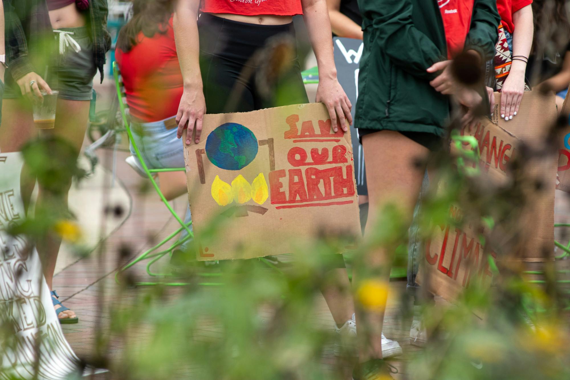 <p>A protester holds a &#x27;save our earth&#x27; sign at the &#x27;Climate 911&#x27; protest in East Lansing on Oct. 10, 2021.</p>