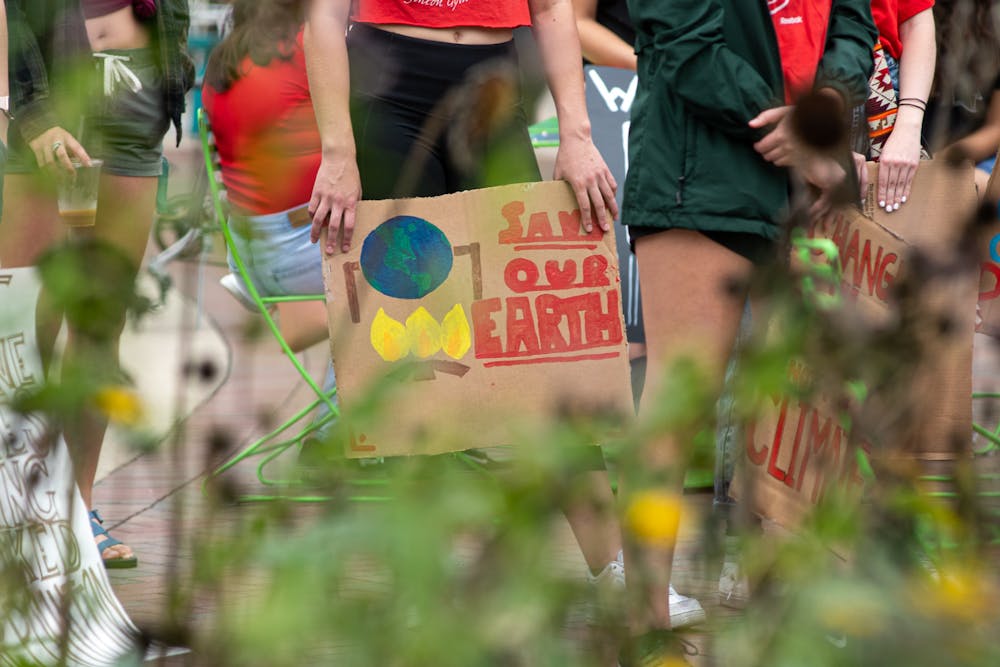 <p>A protester holds a &#x27;save our earth&#x27; sign at the &#x27;Climate 911&#x27; protest in East Lansing on Oct. 10, 2021.</p>