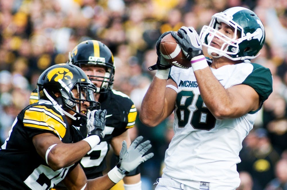 Senior tight end Brian Linthicum hauls in a pass thrown by senior wide receiver Keshawn Martin Saturday at Kinnick Stadium in Iowa City, Iowa. The Spartans defeated the Hawkeyes 37-21. Matt Radick/The State News