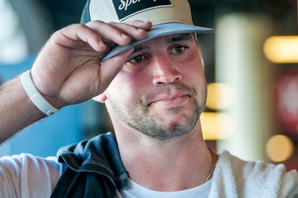 	<p>Drew Stanton, former <span class="caps">MSU</span> football player and current quarterback of <span class="caps">NFL</span> team Arizona Cardinals, adjusts his hat while talking with fans, June 22, 2013, at Cooley Law School Stadium, 505 E. Michigan Ave., in Lansing, after Kick for the House. Students, coaches, and former <span class="caps">MSU</span> student athletes gathered in the annual charity event to raise money for Ronald McDonald House of Mid-Michigan. Justin Wan/The State News</p>