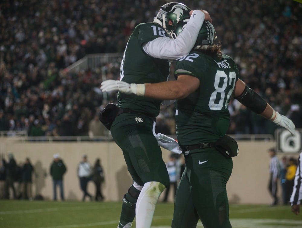 Senior quarterback Connor Cook,18, celebrates with junior tight end Josiah Price, 82, after Price scored a touchdown during the third quarter of the game against Penn State on Nov. 28, 2015 at Spartan Stadium. The Spartans defeated the Nittany Lions, 55-16.