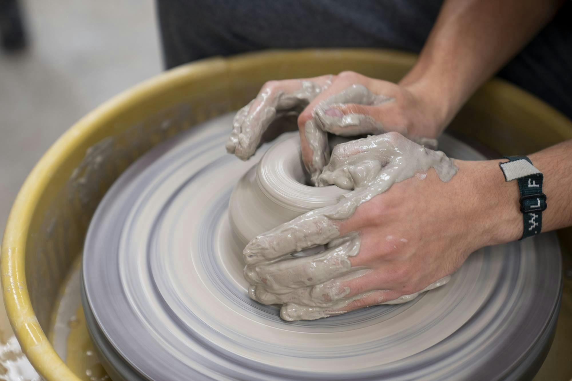 <p>Business junior Trevor Houseworth centers his clay on the wheel as he begins the process of making a vase during Clay Club in the Kresge Art Studio on Oct. 13, 2024.</p>