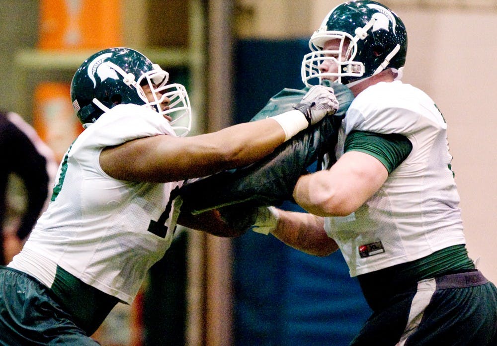 	<p>Senior offensive lineman Arthur Ray Jr., left, runs a drill with junior offensive guard Zach Hueter Tuesday at Duffy Daugherty Football Building. Ray will return to the team this year after missing the past few years while recovering from bone cancer. </p>