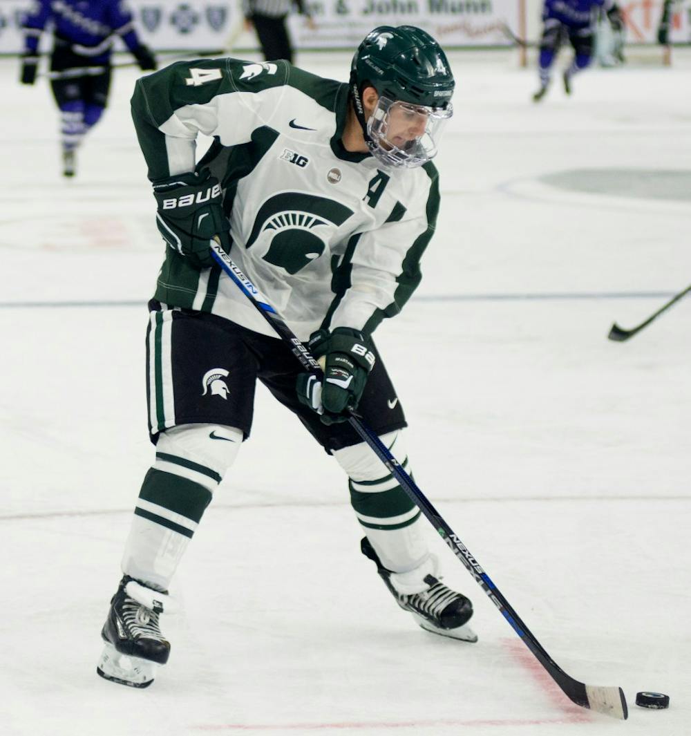 <p>Senior defenseman Travis Walsh looks to pass during the exhibition hockey game against Western Ontario on Oct. 4, 2015 at Munn Ice Arena. The Spartans defeated the Mustangs, 2-1.</p>