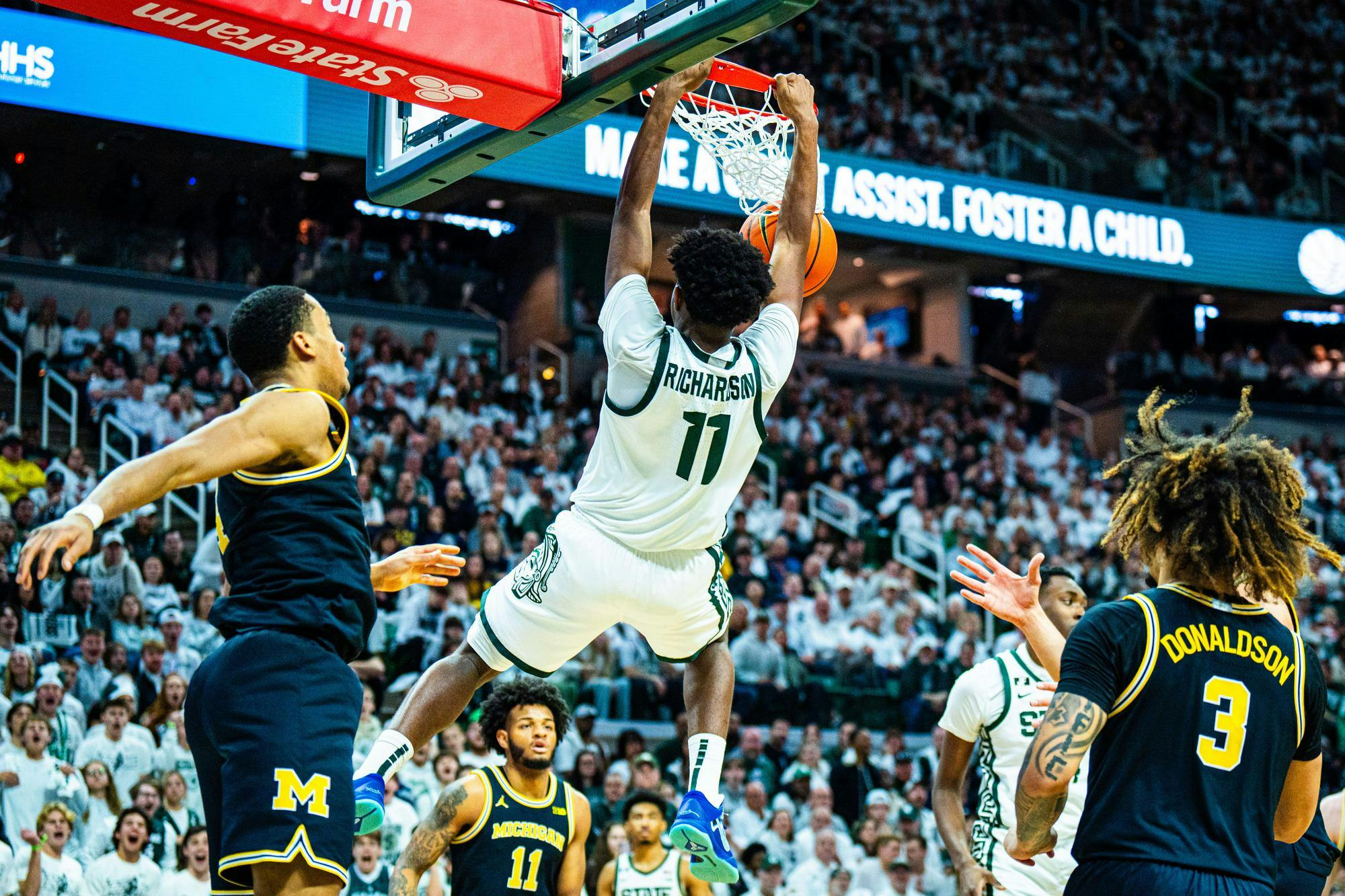 <p>Michigan State freshman guard Jase Richardson (11) swings from the net after dunking at the Breslin Center on March 9, 2025.</p>