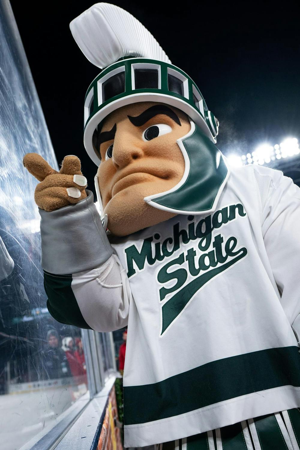 Sparty, the Michigan State mascot, points through the glass at Wrigley Field in Chicago on Jan. 4, 2025. The Spartans' junior forward Daniel Russell (20) netted the overtime winner with under two seconds remaining, earning the weekend sweep over the Badgers.