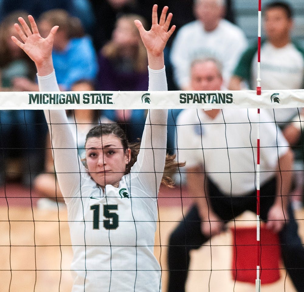 	<p>Junior outside hitter Lauren Wicinski jumps to block a spike Wednesday, Nov. 21, 2012, at Jenison Field House. The Wolverines defeated the Spartans in three straight sets during senior night for the Spartans. Adam Toolin/The State News</p>