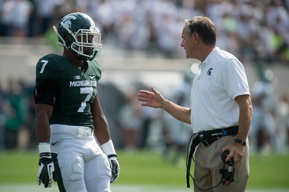 <p>Head coach Mark Dantonio talks to sophomore safety Demetrious Cox in the second quarter during the game against Eastern Michigan on Sept. 20, 2014, at Spartan Stadium. The Spartans defeated the Eagles, 73-14. Julia Nagy/The State News</p>