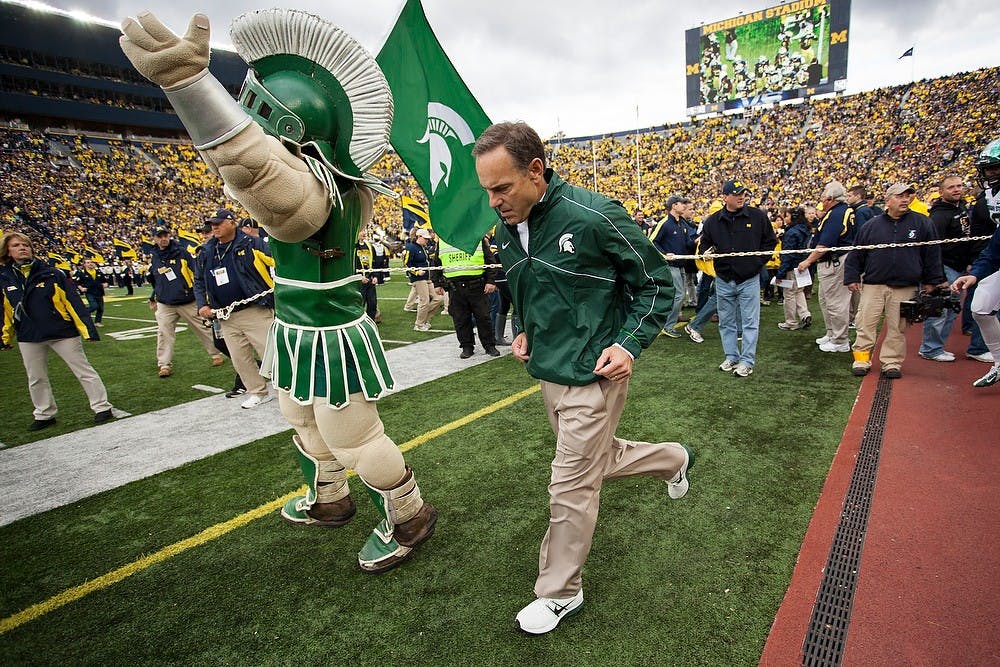 Head coach Mark Dantonio runs with Sparty onto the Michigan Stadium field on Saturday, Oct. 20, 2012. This is the first time in the last five matchups the Wolverines have beaten the Spartans. Julia Nagy/The State News