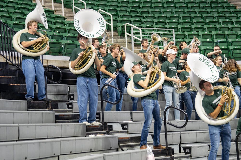 <p>Tuba players in the Spartan Brass band dance and play during Michigan State's volleyball game against Rutgers on Oct. 1, 2023, at the Jack Breslin Student Events Center.</p>