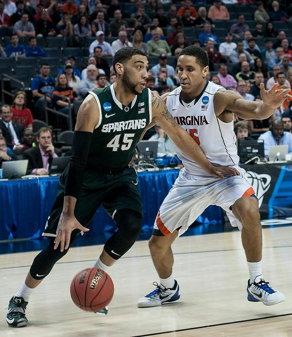 <p>Then junior guard Denzel Valentine dribbles past Virginia junior guard Malcolm Brogdon March 22, 2015, during the Round of 32 of the NCAA tournament in a game against Virginia at the Time Warner Cable Arena in Charlotte, NC. The Spartans defeated the Cavaliers 60-54.  Alice Kole/The State News</p>