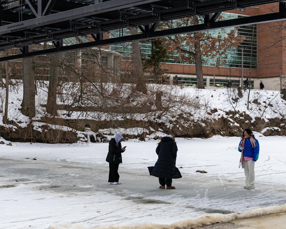 MSU students walk over the frozen over Red Cedar River in East Lansing, MI on Feb. 11, 2026.