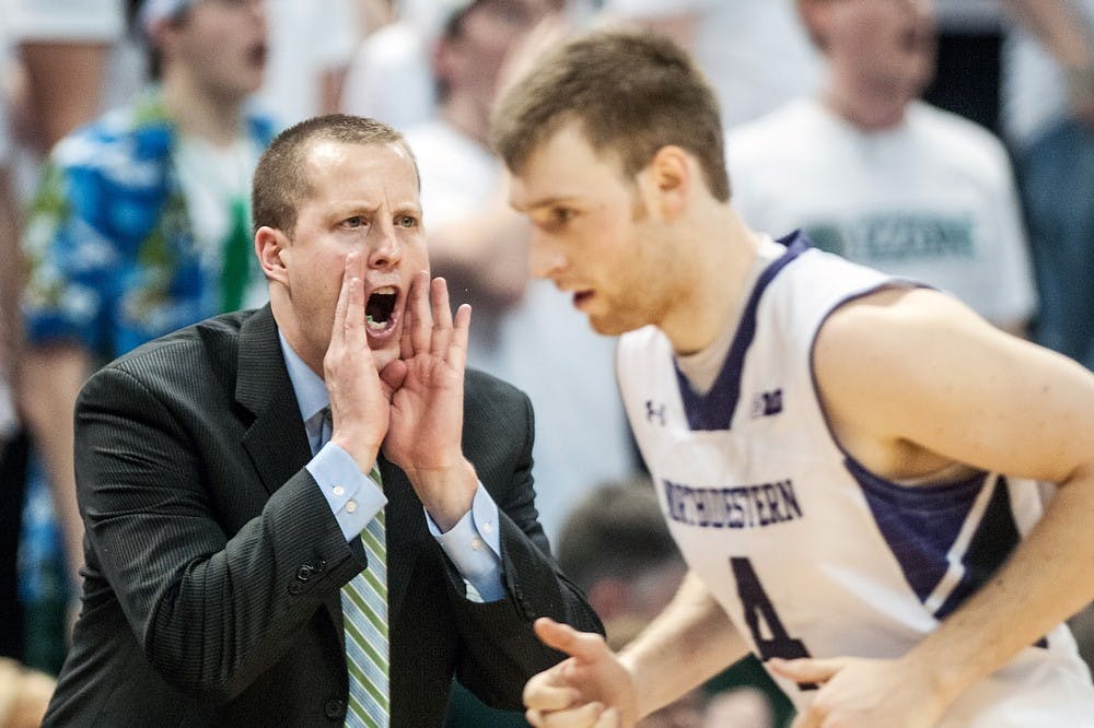 MSU assistant coach Dane Fife yells from the bench in the early second half of the game as Northwestern guard Alex Marcotullio rushes past him. The Spartans defeated the Wildcats, 71-61, on March 10, 2013, at Breslin Center. Justin Wan/The State News