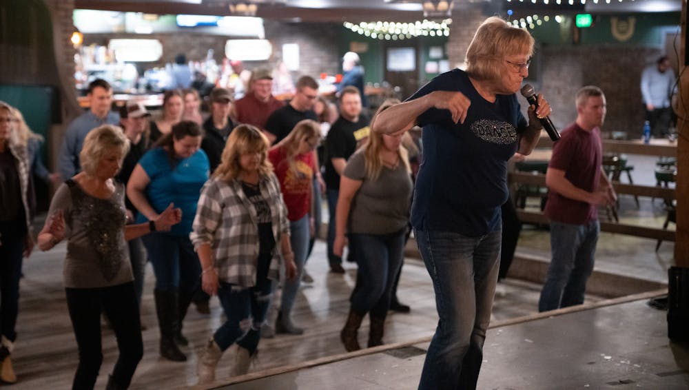 Lois Klender leads the crowd in a line dance at The Junction on Wednesday, Jan. 25, 2023. Klender and her husband served as dance instructors, demonstrating steps to country music.