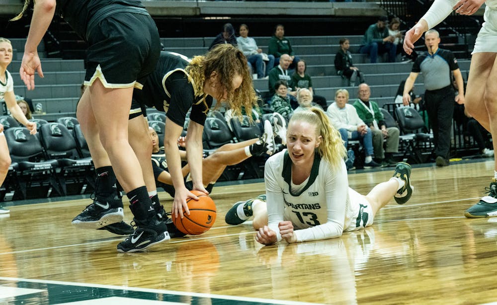 <p>Graduate student guard Stephanie Visscher (13) falls on the ground at the game against Oakland at the Breslin Center on Nov. 15, 2022. The Spartans defeated the Grizzlies 85-39. </p>