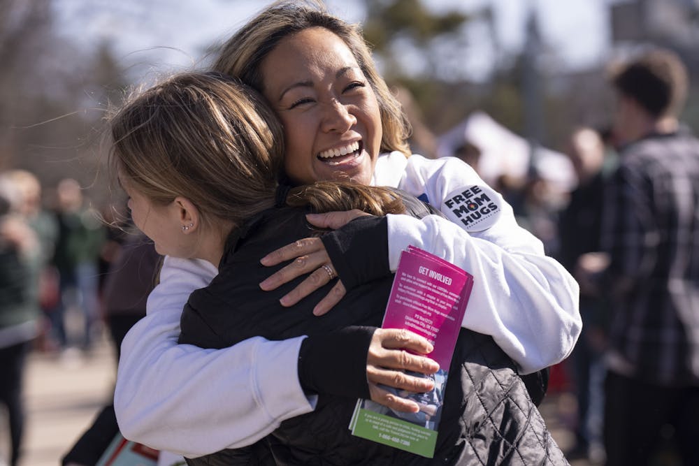 <p>Moms scattered throughout campus offering “Free Mom Hugs” to anyone that needed the extra comfort on Sunday, Feb. 19, 2023, for Spartan Sunday - an event organized by alumni and Spartan parents to welcome students and faculty back to campus. “This is love and strength, this is making our community stronger,” said Thuy Sabo, an alumni and Spartan parent.</p>