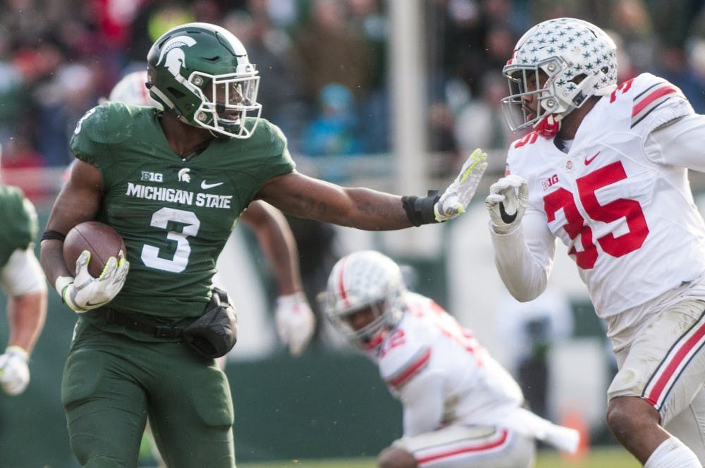 Sophomore running back LJ Scott (3) holds his arm out to fend off Ohio State linebacker Chris Worley (35) during the game against Ohio State on Nov. 19, 2016 at Spartan Stadium. The Spartans were defeated by the Buckeyes, 17-16.