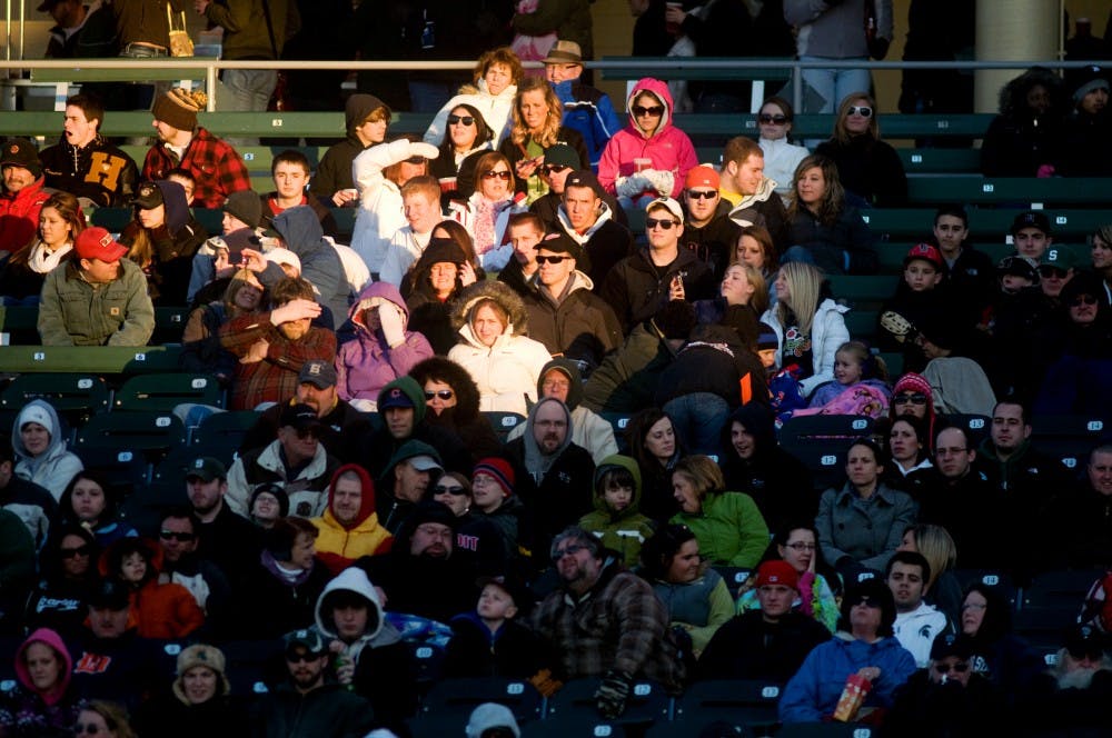 A patch of sun is the last light to hit spectators as they watch the Crosstown Showdown on Tuesday at Cooley Law School Stadium in Lansing. Kat Petersen/The State News
