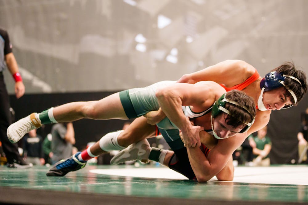<p>Graduate Student Benny Gomez wrestles out of a hold during a meet against the University of Illinois, held at Jenison Fieldhouse on Feb. 5, 2023. The Spartans fell to the Illini 17-16.</p>